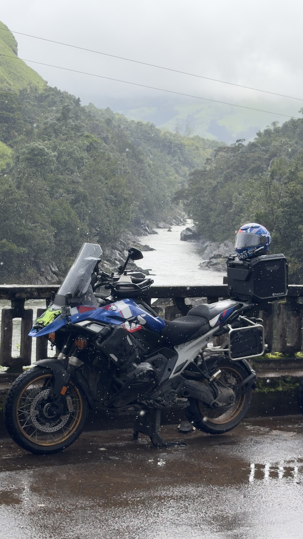 BMW motorcycle beside a river in the rain