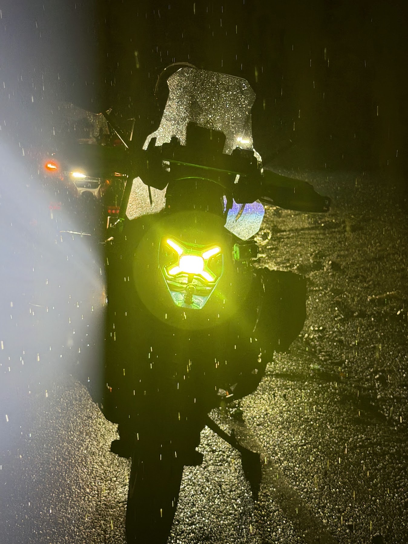 Motorcycle headlights lighting a rainy night ride